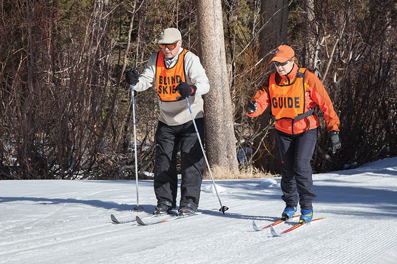 Volunteer Dorie guides Carlos (a visually impaired wounded warrior) as he learns to cross country ski