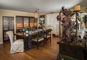 Sliding screens close off the kitchen from the dining and living rooms. Chinese treasures include an antique white wedding dress